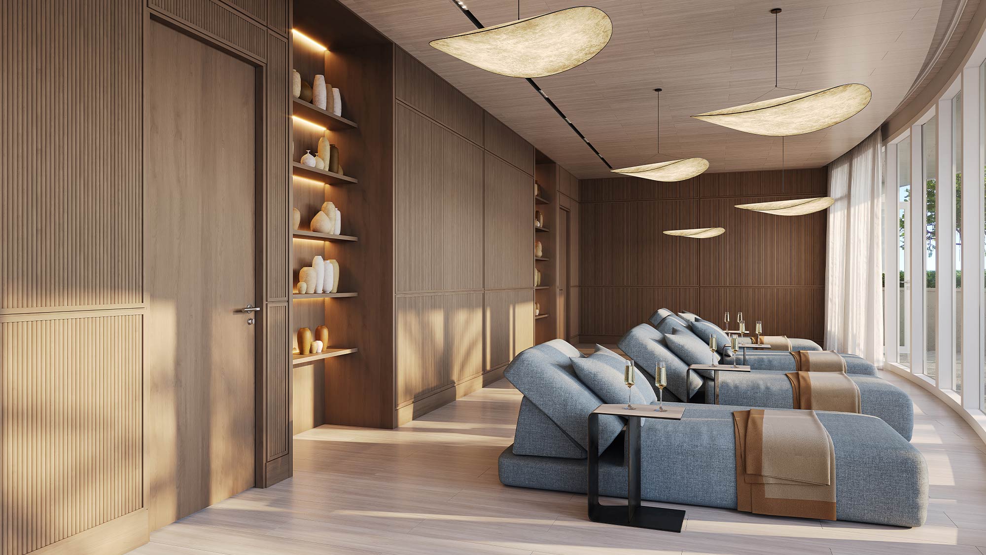 Viceroy spa relaxation lounge with blue recliners, warm wood paneling, organic pendant lights, shelving, natural light